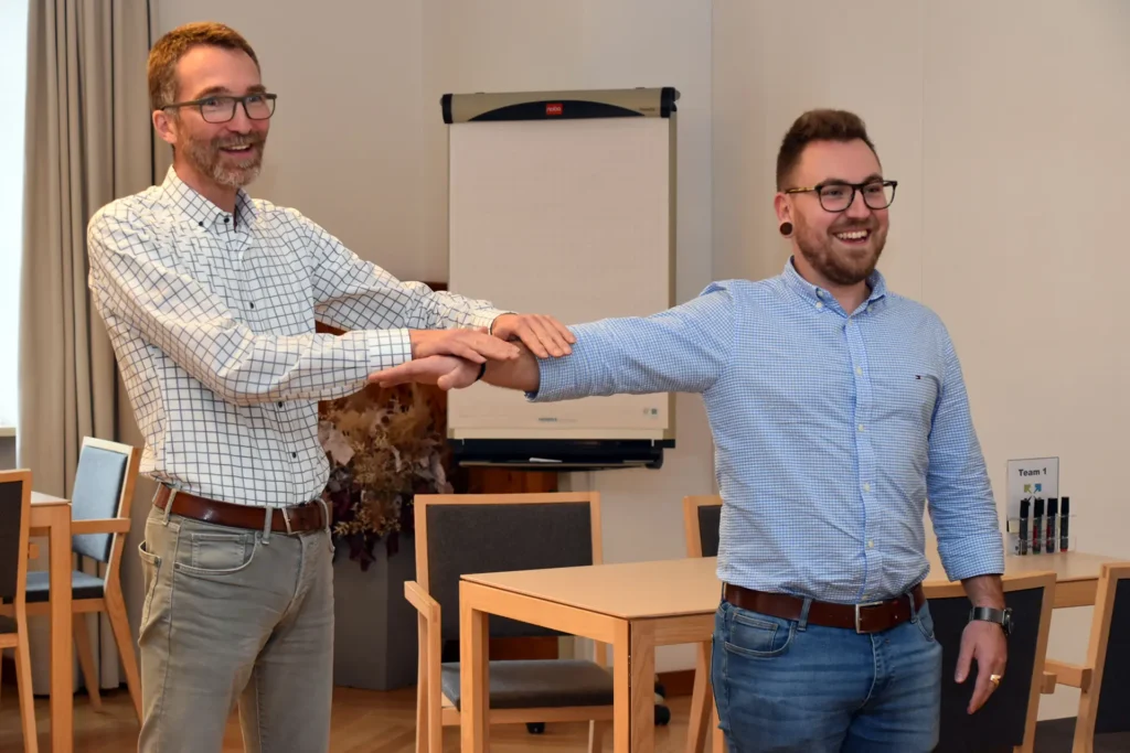 Zwei Teilnehmer nehmen bei einer Übung zum Thema Positive Leadership teil und haben großen Spaß daran