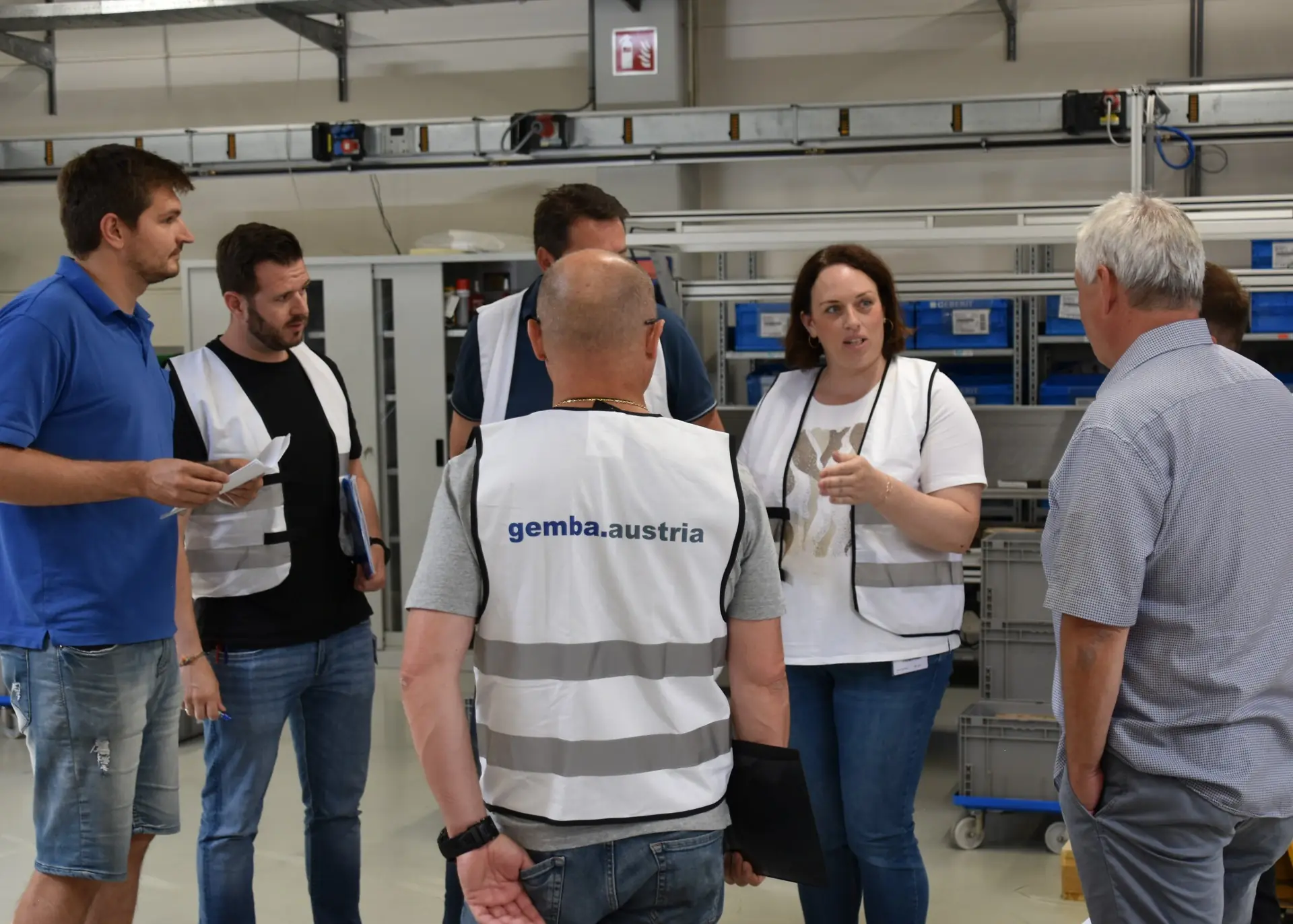 5S Methode in der Produktion: Team führt eine Shopfloor-Besprechung durch und diskutiert nachhaltige Verbesserungen am Arbeitsplatz.